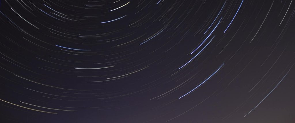 Low angle view of star trails in sky at night
